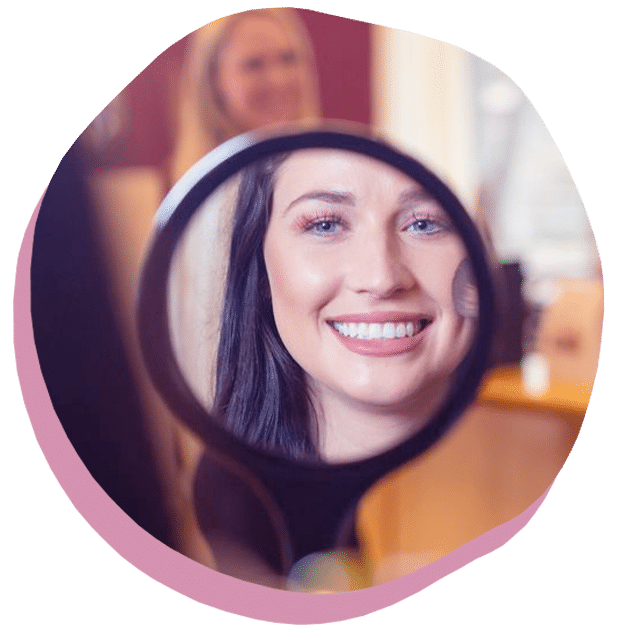 A Woman Smiling In Front Of A Mirror Posing For The Camera