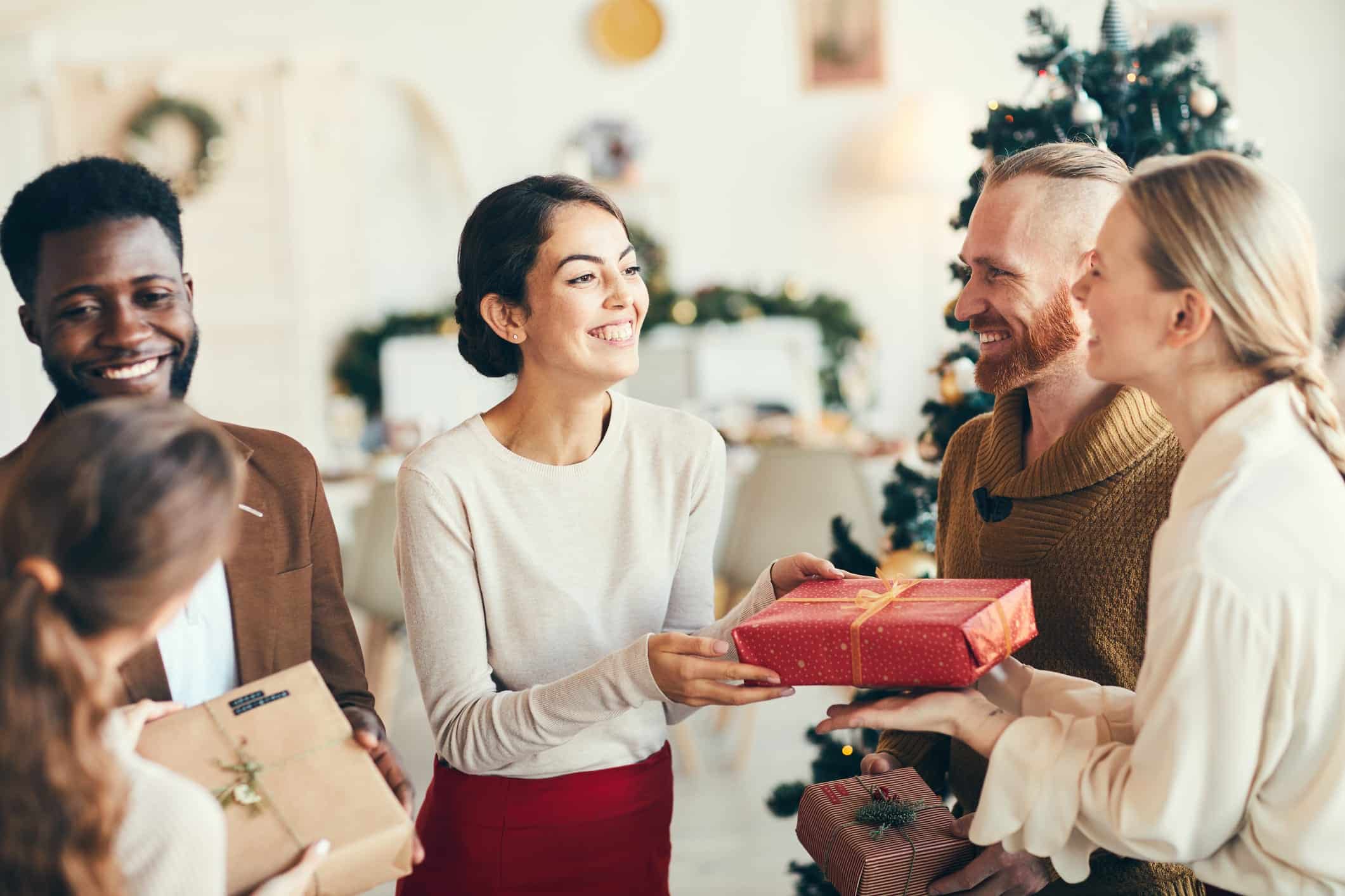 A group of friends exchange presents, proud of the best skincare product Christmas gift ideas they’ve thought of for each other.