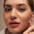 a close up of a girl smiling and looking at the camera